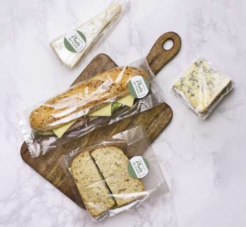 Vegware_concept_bagstogo_VGN3_VGN4_VGN5_VGN6_sandwiches_cookies_cheese_popcorn_stickers_marble_board_overhead_wide NatureFlex multi-bag 220 x 180mm clear film