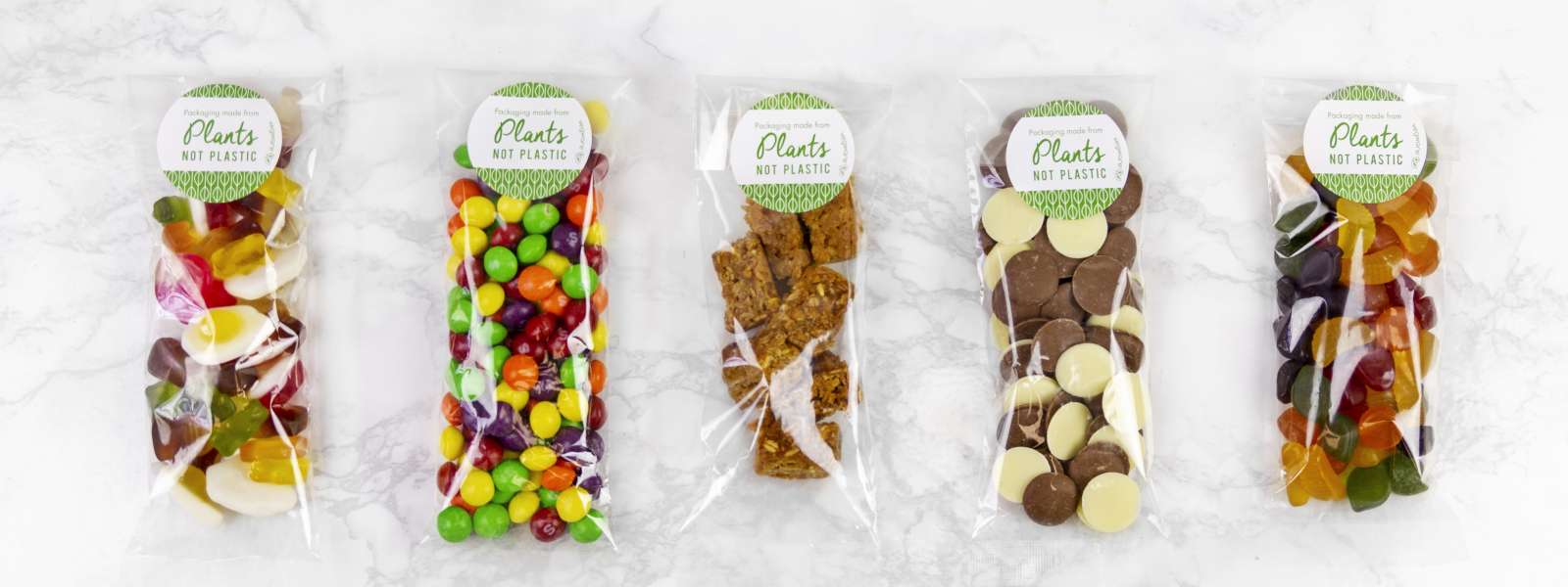 Vegware_concept_bagstogo_VGN1_Vegware_concept_bagstogo_VGN1_sweets_overhead_lineup_ clear film greaseproof NatureFlex bag